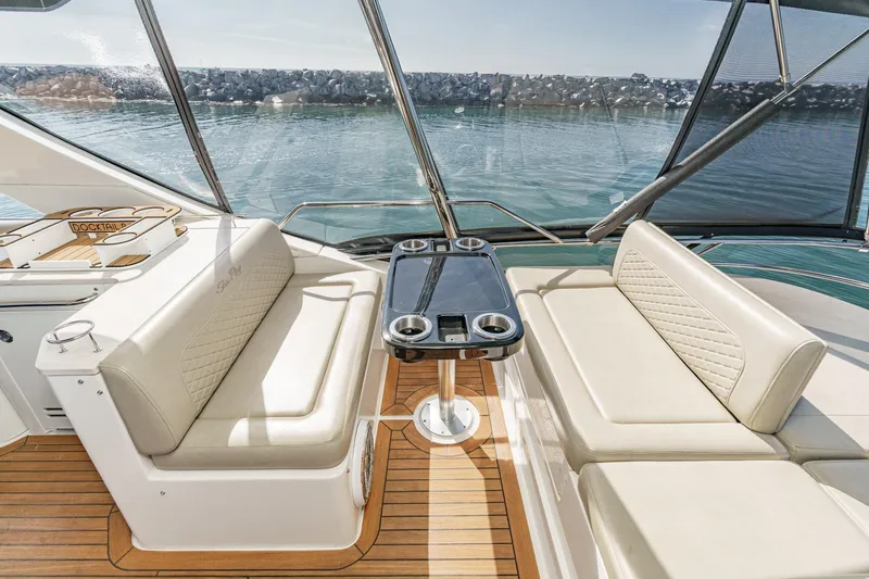 Slide: The Image of Luxurious 2018 Sea Ray Fly 510 yacht interior with elegant seating and table, overlooking serene waters. - 52