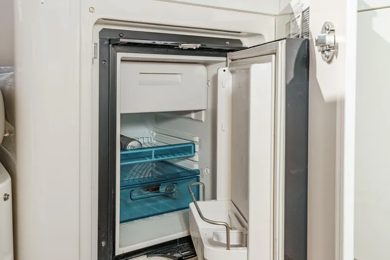 Slide: The Image of Open refrigerator on 2018 Sea Ray Fly 510 yacht, showcasing interior shelves and storage. - 57