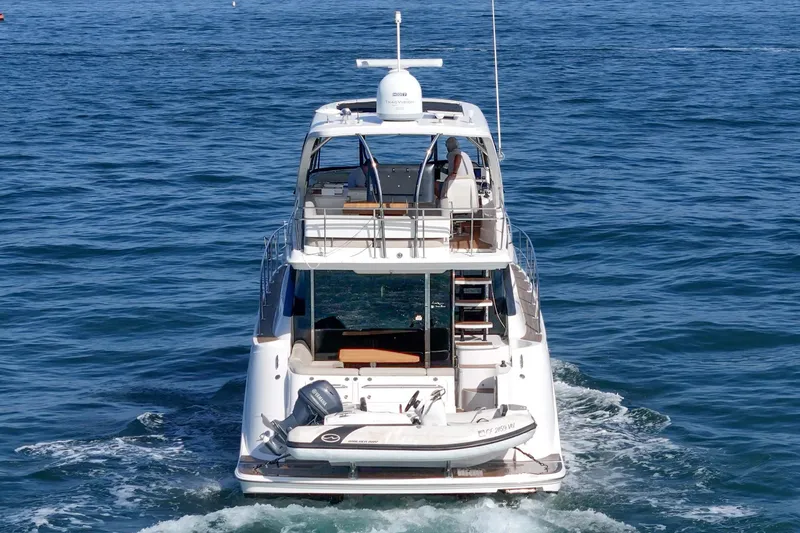 Slide: The Image of 2018 Sea Ray Fly 510 yacht cruising on open water, rear view. - 6
