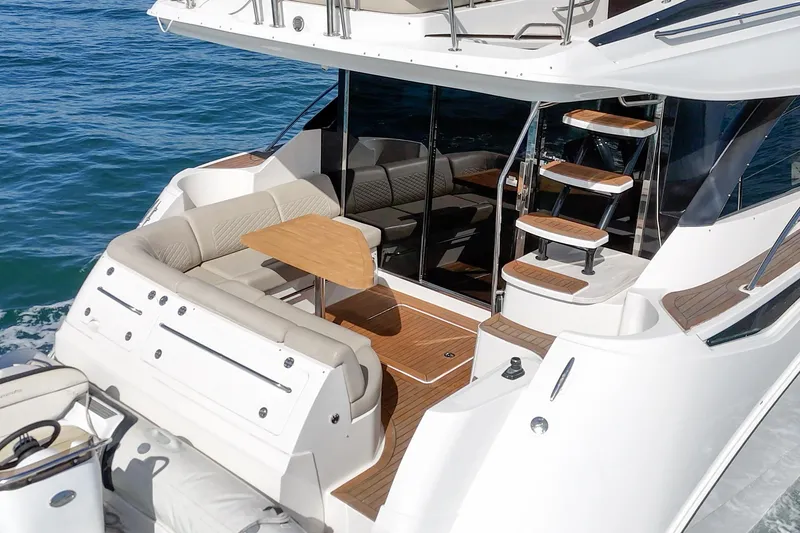 Slide: The Image of Luxurious 2018 Sea Ray Fly 510 yacht with elegant seating and wooden accents. - 8