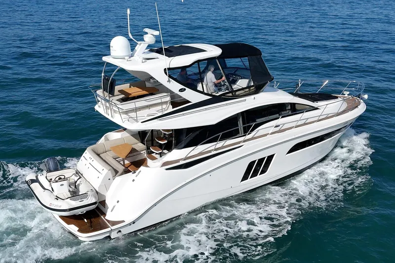 Slide: The Image of 2018 Sea Ray Fly 510 yacht cruising on open water, showcasing luxury design. - 9