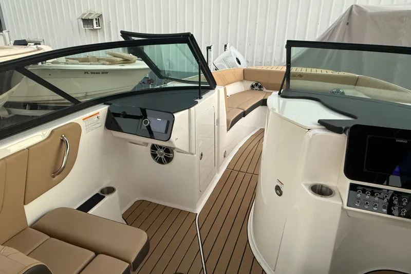 Slide: The Image of 2025 Sea Ray SDX 270 Outboard interior with tan seating and modern dashboard. - 10