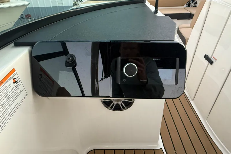 Slide: The Image of 2025 Sea Ray SDX 270 Outboard dashboard with Fusion audio system and teak flooring. - 11