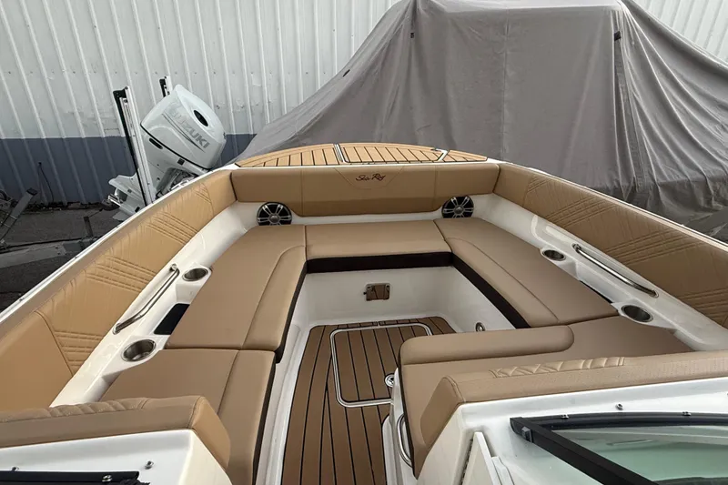 Slide: The Image of 2025 Sea Ray SDX 270 Outboard boat interior with tan seating and wood accents. - 12
