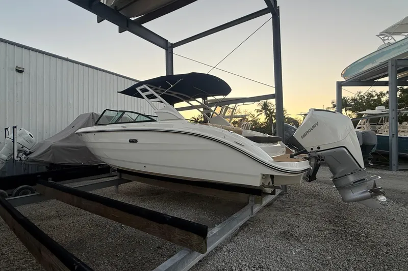 Slide: The Image of 2025 Sea Ray SDX 270 Outboard boat on trailer, parked in a marina at sunset. - 4