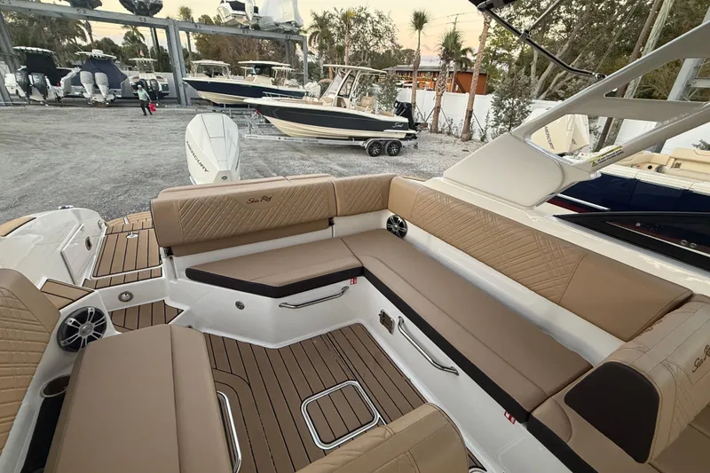 Slide: The Image of 2025 Sea Ray SDX 270 Outboard boat interior with tan seating and wood accents. - 6