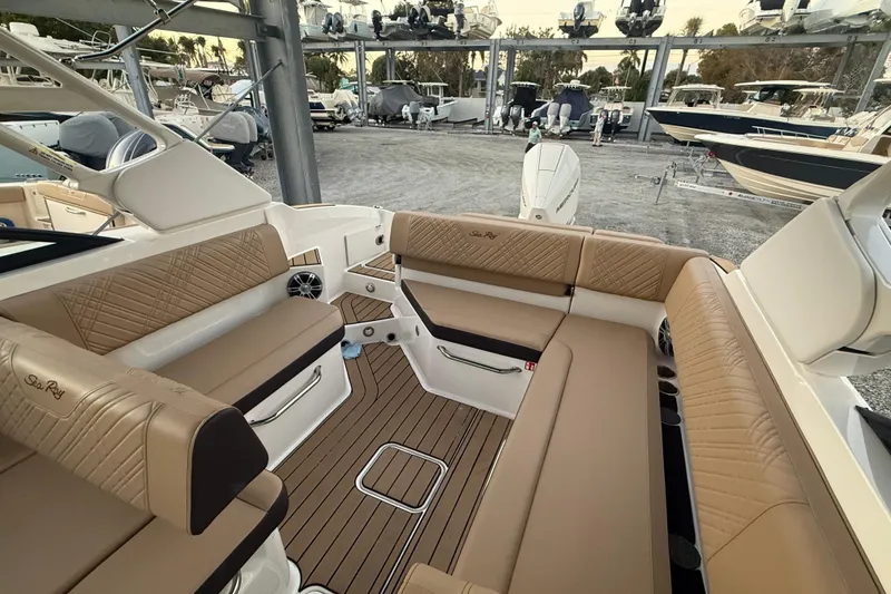 Slide: The Image of 2025 Sea Ray SDX 270 Outboard interior with tan seating and wood flooring. - 7