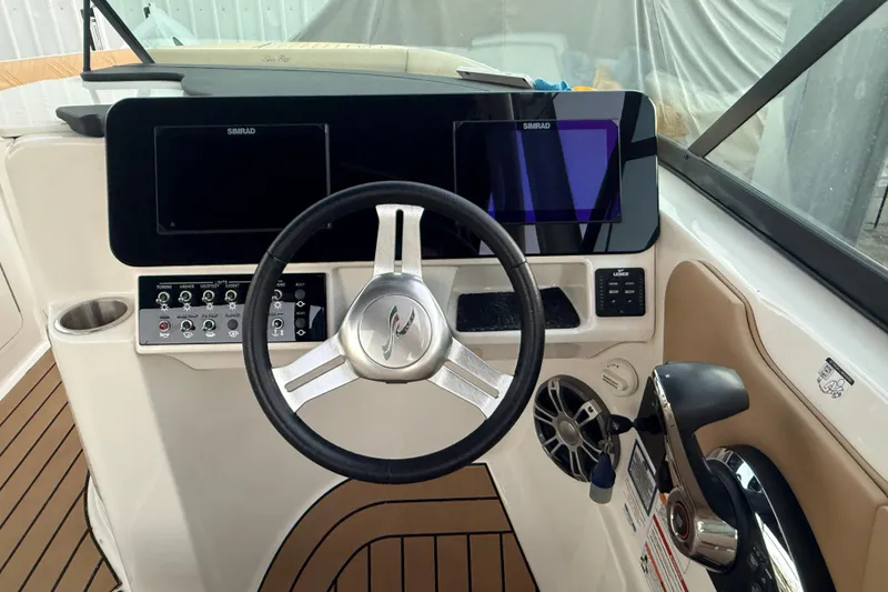 Slide: The Image of 2025 Sea Ray SDX 270 Outboard dashboard with steering wheel and control panel. - 9
