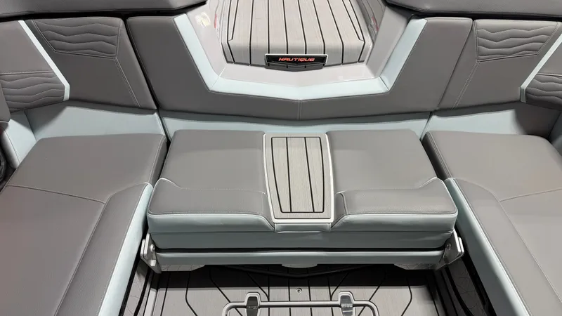 Slide: The Image of The image shows the interior of a 2026 Nautique Super Air Nautique G25 with gray upholstery. - 32