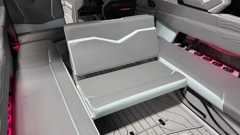 Slide: The Image of The interior of the 2026 Nautique Super Air Nautique G25 features gray upholstery with pink accents. - 34