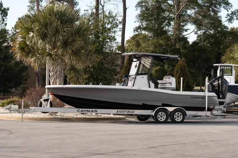 The Image of 2026 Caymas 28 HB boat on trailer, parked near palm trees. - 1
