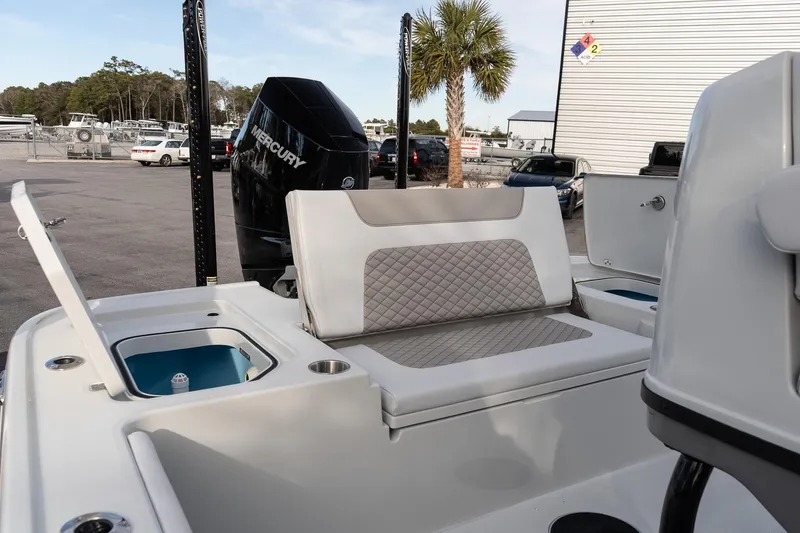 Slide: The Image of 2026 Caymas 28 HB boat interior with seating and Mercury engine in a marina setting. - 11