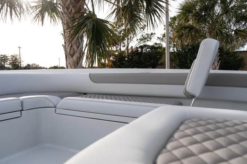 Slide: The Image of 2026 Caymas 28 HB boat interior with quilted seating, palm trees in background. - 24