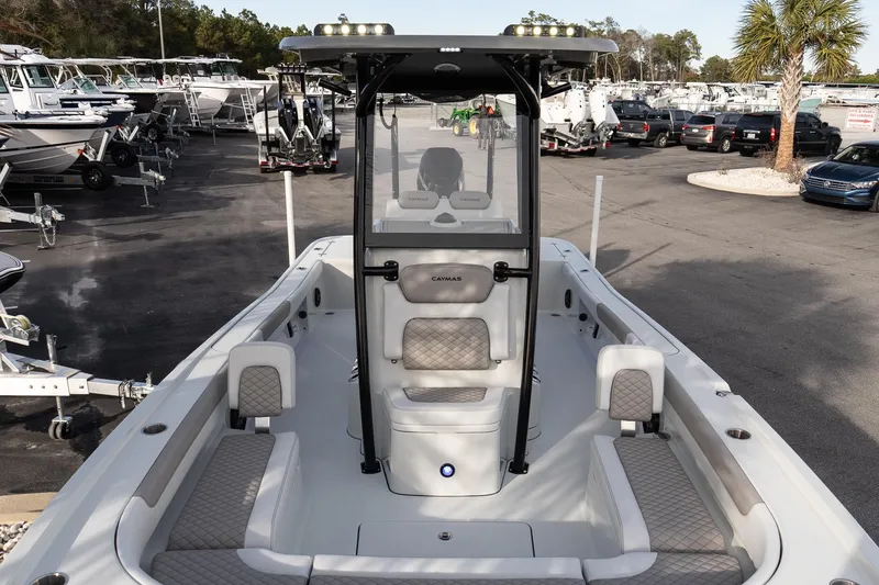Slide: The Image of 2026 Caymas 28 HB boat with spacious seating, parked in a marina. - 26