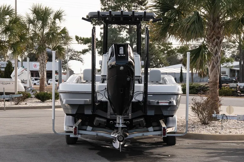 Slide: The Image of 2026 Caymas 28 HB boat on trailer, parked near palm trees. - 6