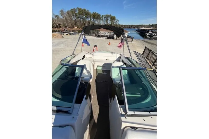 Slide: The Image of 2005 Regal 2200 Bowrider boat docked, featuring open seating and clear skies. - 8