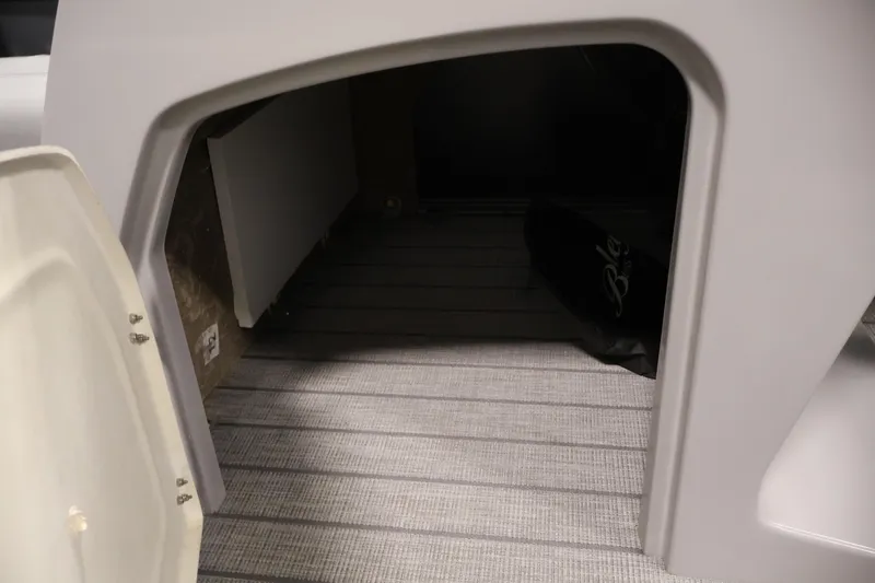 Slide: The Image of Storage compartment of 2026 Bentley Pontoons 223 Navigator Tri-toon, featuring open door and interior view. - 18