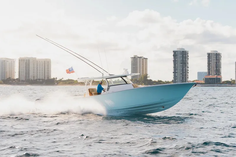 Slide: The Image of 2026 Sportsman Open 402 Center Console cruising on water near city skyline. - 3