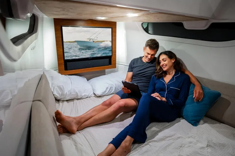 Slide: The Image of Couple relaxing in Sportsman Open 402 Center Console cabin, 2026 model. - 7