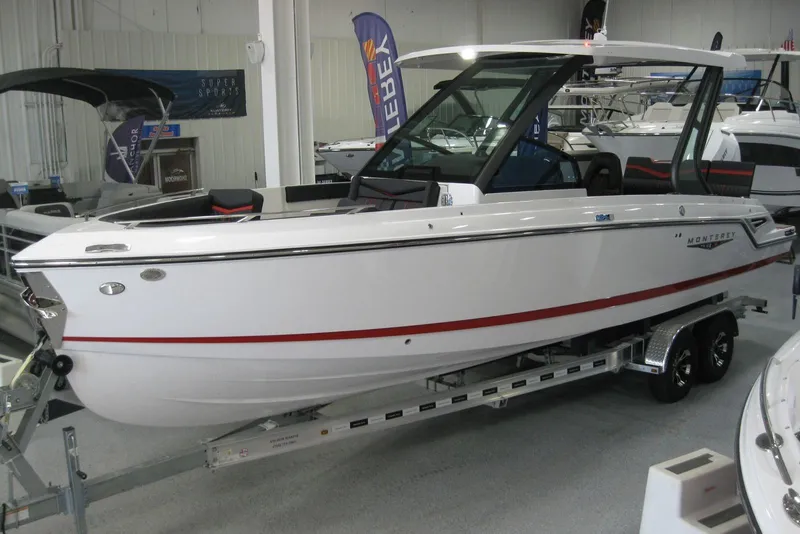 Slide: The Image of 2025 Monterey Elite 27 OB boat on trailer outside marine dealership. - 2