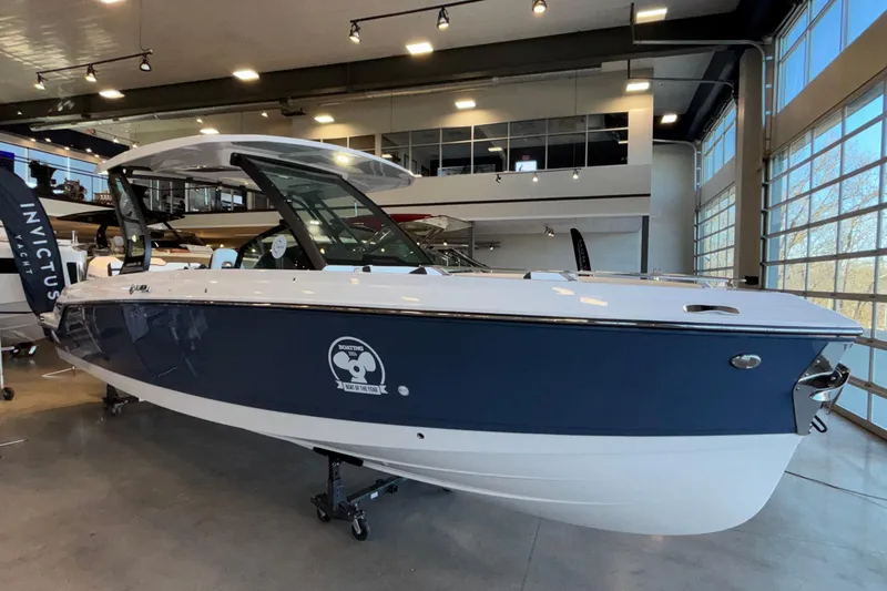 Slide: The Image of 2026 Monterey Elite 30 OB boat displayed in a modern showroom. - 103