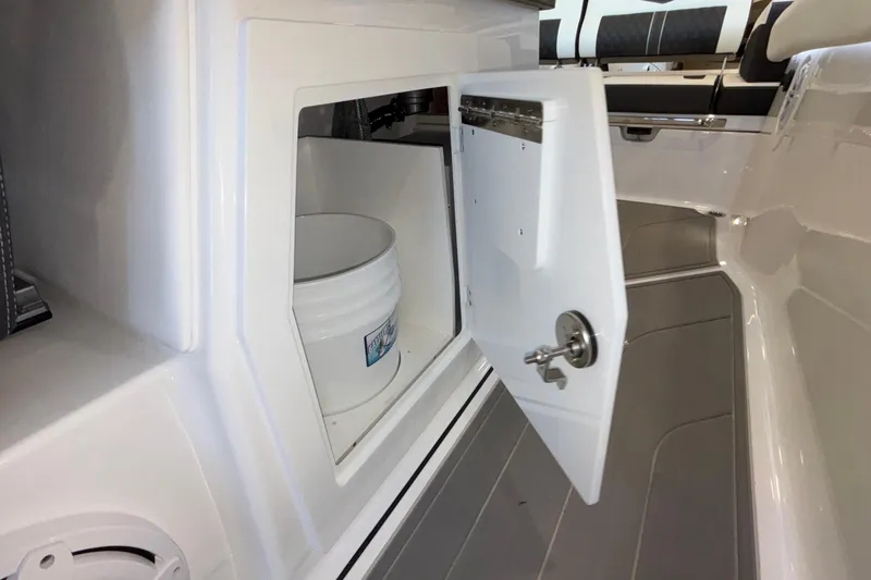 Slide: The Image of Storage compartment on 2026 Monterey Elite 30 OB boat with open door and bucket inside. - 43