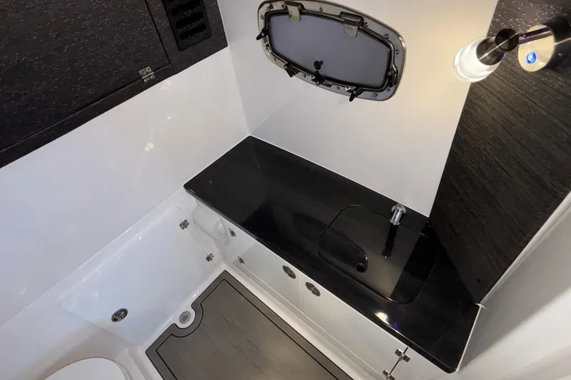 Slide: The Image of Modern bathroom interior of 2026 Monterey Elite 30 OB boat, featuring sleek black countertop. - 76