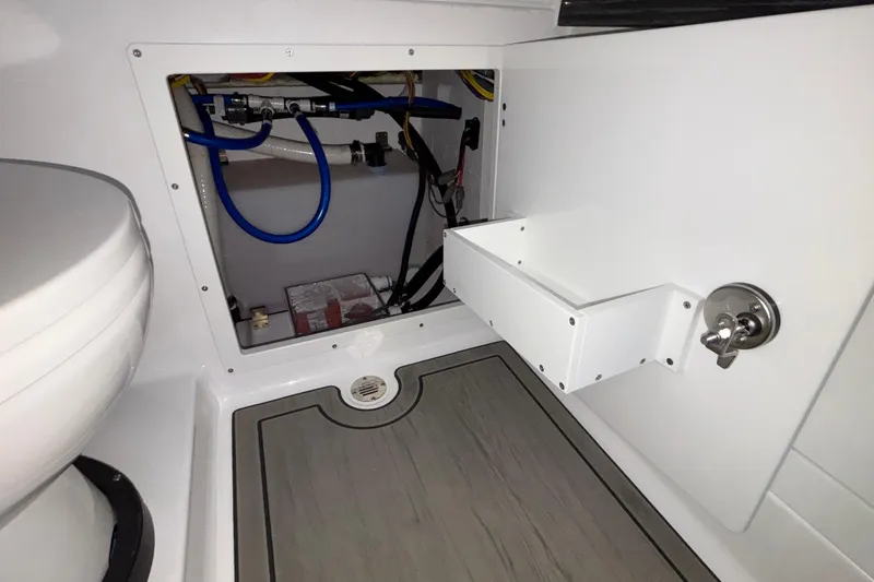 Slide: The Image of Interior view of 2026 Monterey Elite 30 OB boat's storage compartment and plumbing. - 80