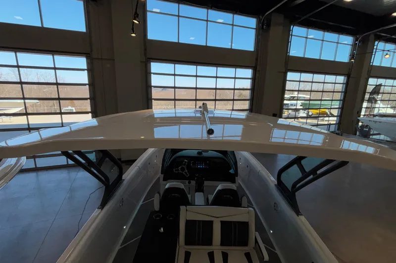Slide: The Image of 2026 Monterey Elite 30 OB boat interior in a showroom with large windows. - 95