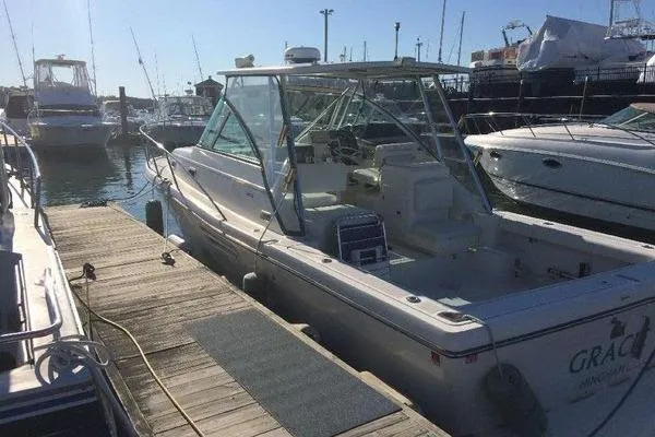 Slide: The Image of 2001 Pursuit 3000 Express boat docked at marina under clear sky. - 1