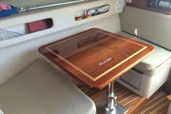 Slide: The Image of Interior of 2001 Pursuit 3000 Express boat with wooden table and seating area. - 12