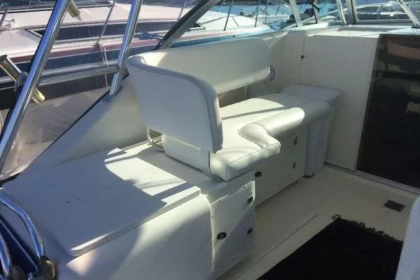 Slide: The Image of 2001 Pursuit 3000 Express boat interior with white seating and storage compartments. - 3