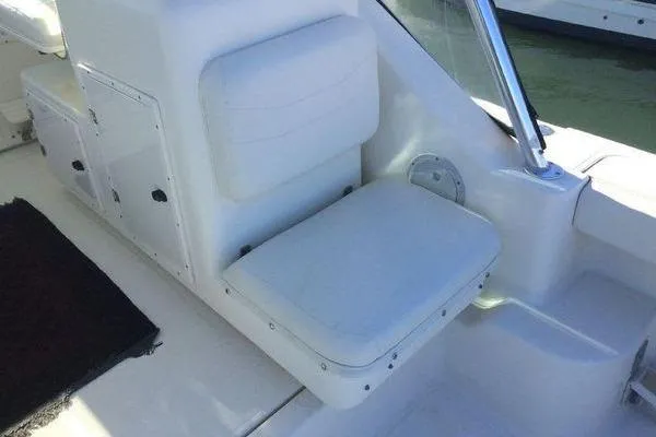 Slide: The Image of 2001 Pursuit 3000 Express boat interior with white seating and storage compartments. - 6