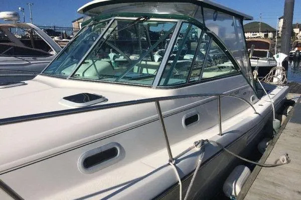 Slide: The Image of 2001 Pursuit 3000 Express boat docked at marina, showcasing sleek design and glass cabin. - 8