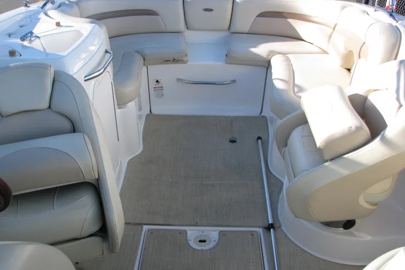 Slide: The Image of 2004 Chaparral 260 SSi boat interior with beige seating and carpeted floor. - 6