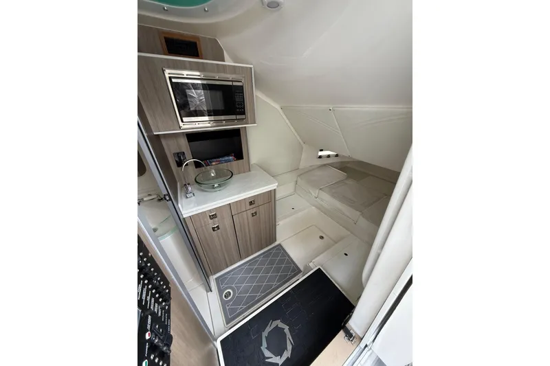 Slide: The Image of 2021 Fountain 43 NX boat anchor compartment with control panel, on calm blue water. - 31