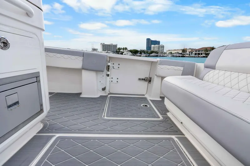 Slide: The Image of 2021 Fountain 43 NX boat interior with gray flooring and white seating, cityscape in background. - 38