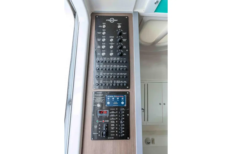 Slide: The Image of Control panel of 2021 Fountain 43 NX boat, featuring switches and digital display. - 60