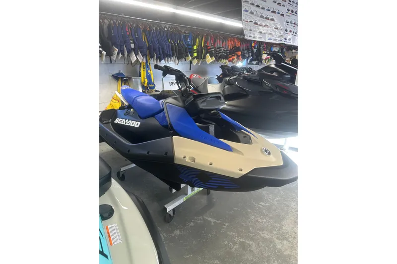 The Image of 2025 Sea-Doo Spark Trixx for 3, blue and beige, displayed in showroom. - 0