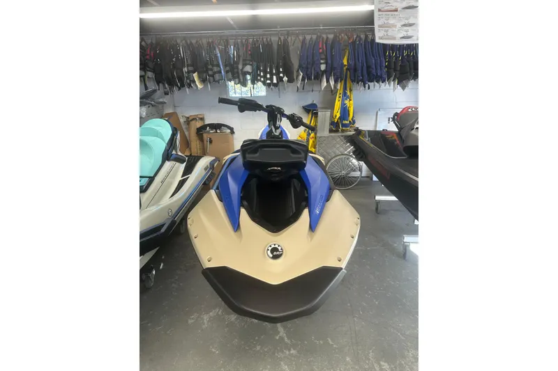 Slide: The Image of 2025 Sea-Doo Spark Trixx for 3 in showroom, blue and beige color scheme. - 2