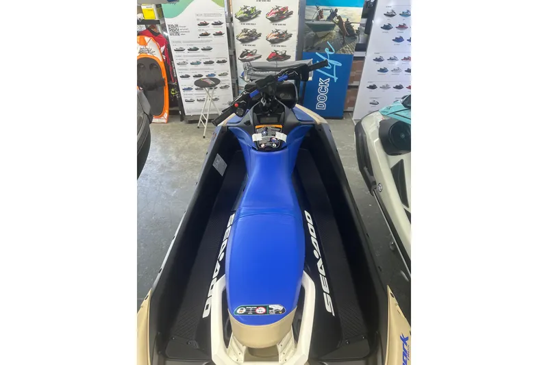 Slide: The Image of 2025 Sea-Doo Spark Trixx for 3, blue seat, displayed in showroom. - 7