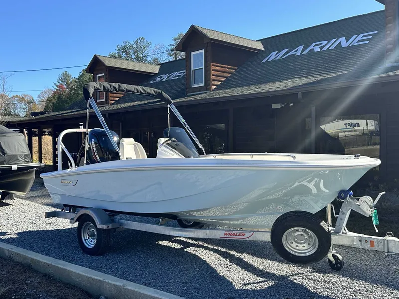 The Image of 2025 Boston Whaler 160 Super Sport in front of a marine shop. - 1