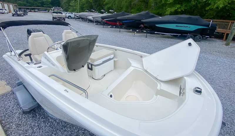 Slide: The Image of Boston Whaler 130 Super Sport 2025 on gravel lot with other boats. - 7