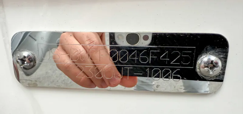 Slide: The Image of Boston Whaler 230 Outrage 2025 serial number plate with reflective surface. - 14