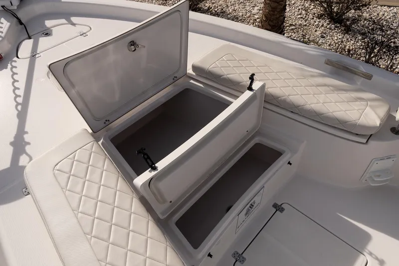 Slide: The Image of 2020 Blue Wave 2600 PureBay boat with open storage compartments and cushioned seating. - 18