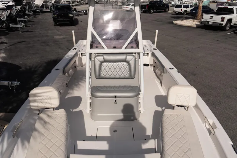 Slide: The Image of 2020 Blue Wave 2600 PureBay boat interior with diamond-stitched seating, parked in a marina. - 20