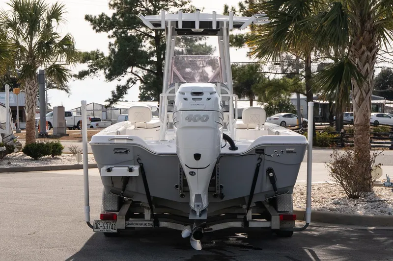Slide: The Image of 2020 Blue Wave 2600 PureBay boat on trailer, parked near palm trees. - 5
