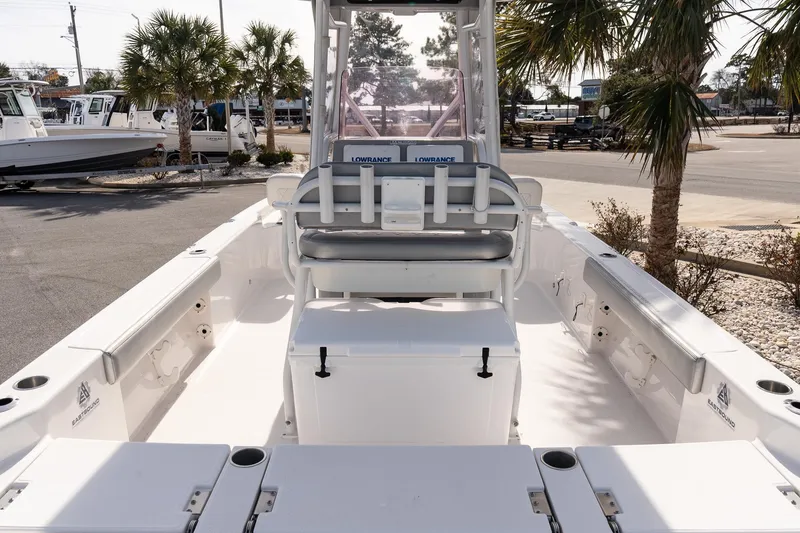 Slide: The Image of 2020 Blue Wave 2600 PureBay boat interior with seating and console, parked outdoors. - 8