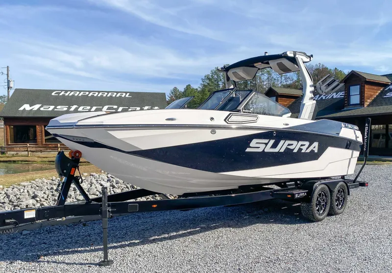 Slide: The Image of 2024 Supra SL boat on trailer in front of store. - 3