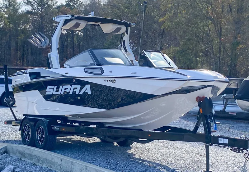 Slide: The Image of 2024 Supra SL boat parked on trailer outdoors. - 5